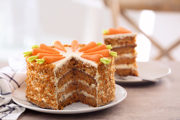 Delicious sliced carrot cake on blurred background