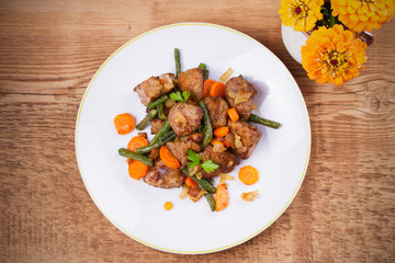 Sauteed liver with vegetables on white plate. View from above, top studio shot