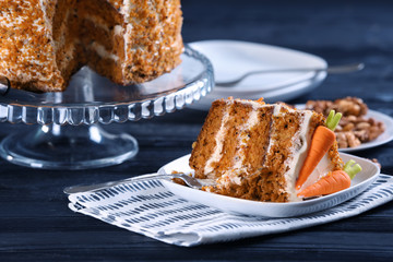 Plate with piece of delicious carrot cake on table