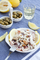 traditional mediterranian seafood appetizers with olives, lemons and white wine