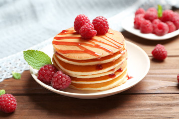Plate with delicious pancakes on table
