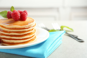 Delicious pancakes with raspberries on plate