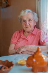 An elderly woman in her home, portrait at kitchen.