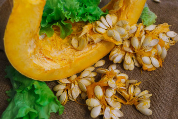Pieces of yellow pumpkin together with seeds and greens.