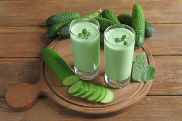 Obraz na płótnie Canvas Composition with fresh smoothie and cucumbers on wooden background