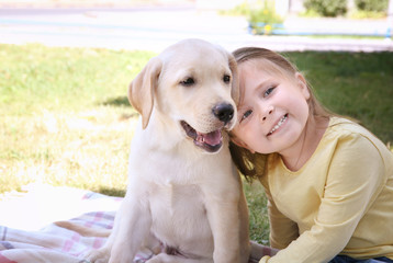 Cute child with Labrador Retriever outdoors
