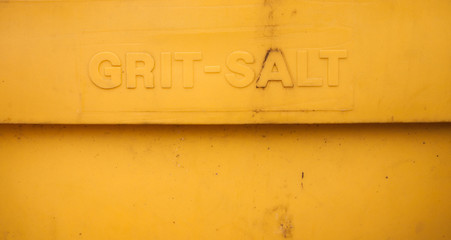 close up of yellow grit salt lettering on plastic container