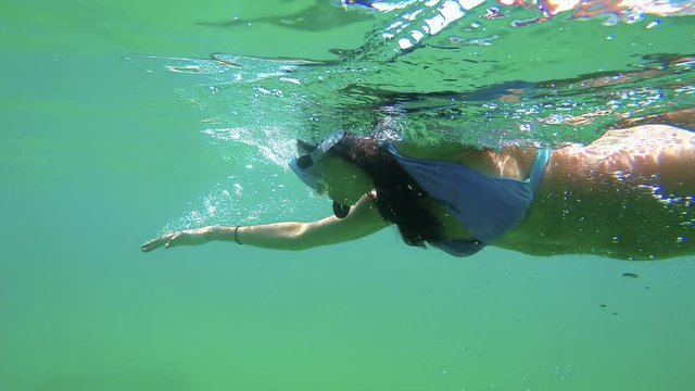Young Spanish girl swimming freestyle style in the transparent water in Costa Brava in Spain