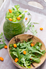 Rucola smoothie, on the grey  background.