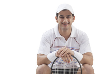Portrait of young man with tennis racket isolated over white background