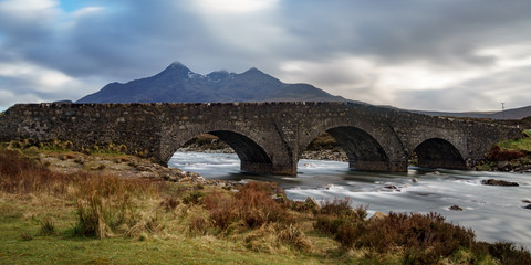The beautiful old bridge crossing a river in front of the Black Cuillin mountain scenery from Glen Brittle on the Isle of Skye, Scotland