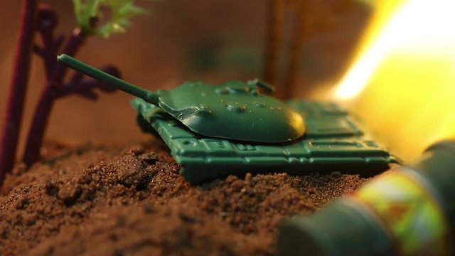 Fire engulfs toy tank, macro close up