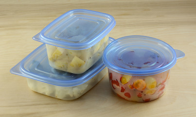 Chopped dinner ingredients of cauliflower, potatoes and cherry tomatoes in plastic refrigerator...