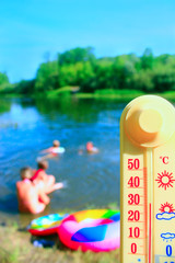 thermometer with indication 31 degrees and bathing people