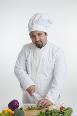 Portrait of chef cutting vegetables