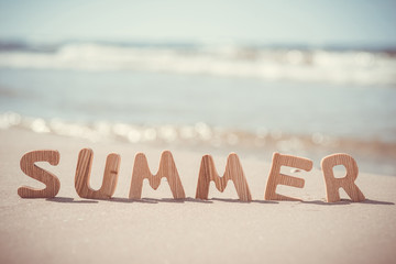 Summer. Wooden letters on the sand