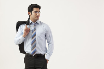 Young businessman with hand in pocket looking away 