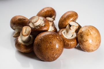 A pile of brown champignon mushrooms isolated on a white background