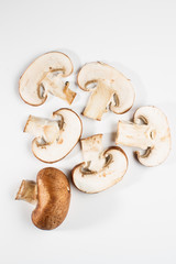 Mix of whole and sliced brown champignon mushrooms isolated on a white background