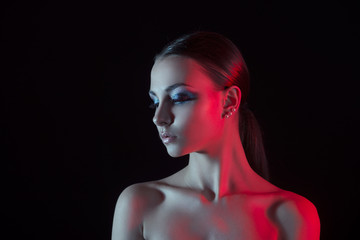 glamorous portrait of a girl in a red lighting on black background isolated