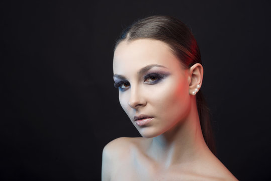 Portrait of a girl with clean skin and bright makeup on black  isolated  background