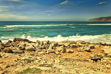 Fototapeta na wymiar Cliffs and rocks on the Atlantic ocean coast in Sintra in a beautiful summer day. Portugal