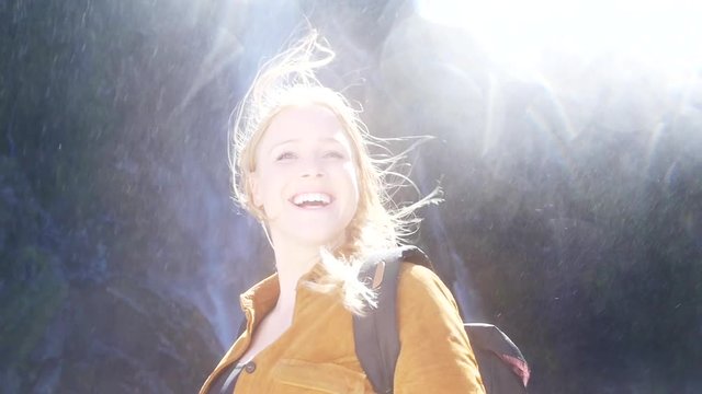 Blonde woman backpacker, Milford Sound waterfall slow motion