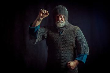 Portrait of praying Templar knight on a dark background.