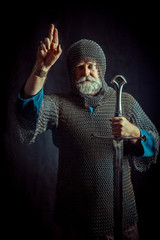 Portrait of praying Templar knight on a dark background.