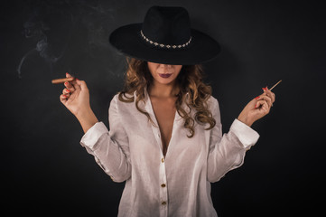 Portrait of sexy elegant lady woman with hat smoking cigar