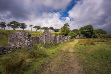 Old Tin Mine, old ruined granite buildings set on Dartmoor.. Dartmoor National Park is vast moorland in the county of Devon, England UK.