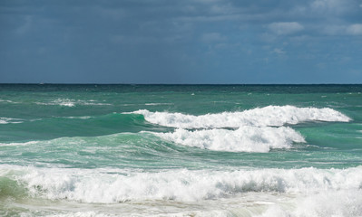 Crushing waves, white puffy clouds, blue sly  