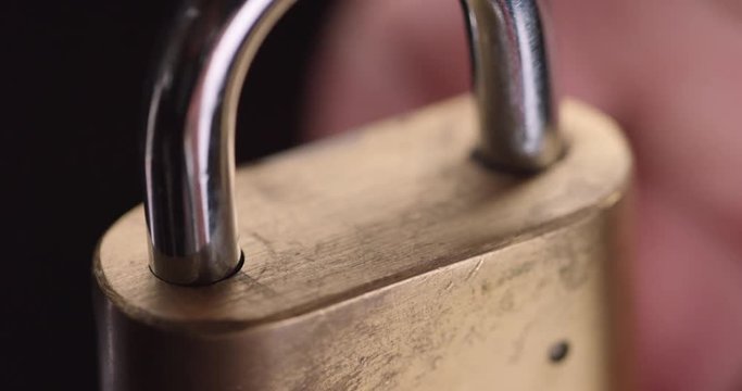 Person locks padlock, close up
