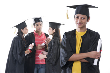 Portrait of confident graduate student with friends discussing against white background