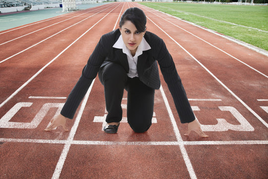 Portrait of confident businesswoman at starting line on race track
