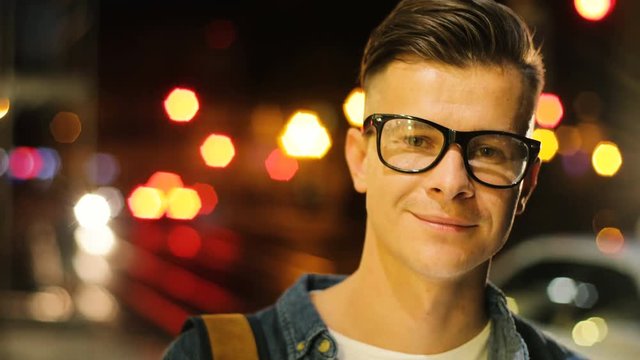 Portrait of young handsome man with stylish glasses in the city centre at the evening time.