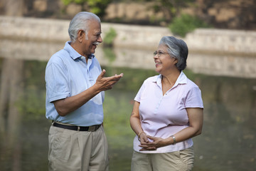 Happy relaxed couple talking in park 