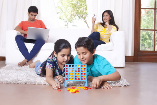Kids playing while parents sit on sofa