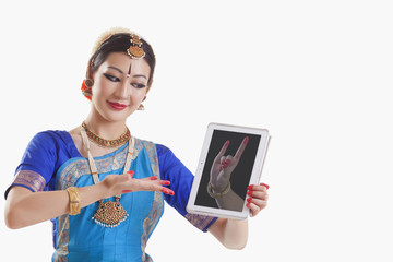 Bharatanatyam dancer showing Simhamukha mudra on digital tablet over white background