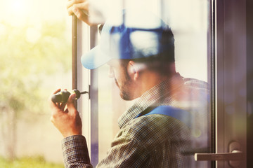 service man installing window with screwdriver - 167304006