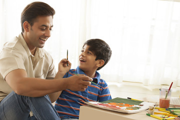 Father and son painting with water colors 