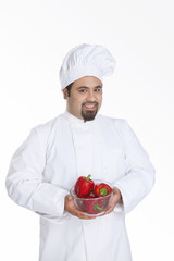 Portrait of chef with bowl of red capsicum