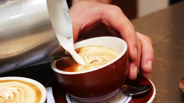Barista creates latte art, slow motion close up