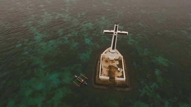 Aerial view Sunken Cemetery cross in Camiguin Island, Philippines. Large crucafix marking the underwater sunken cemetary of the coast of camiguin island near mindanao in the Philippines. Catholic