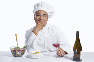 Chef with glass of wine thinking