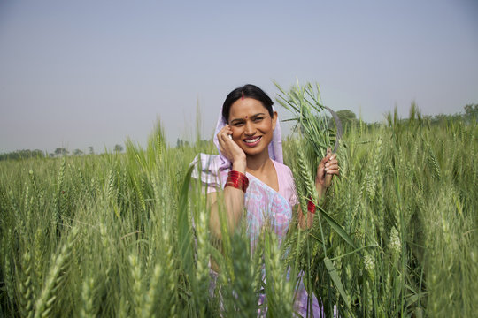 Portrait of an Indian female farm worker talking on phone 