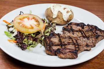 Roast beef steak with potato and salad