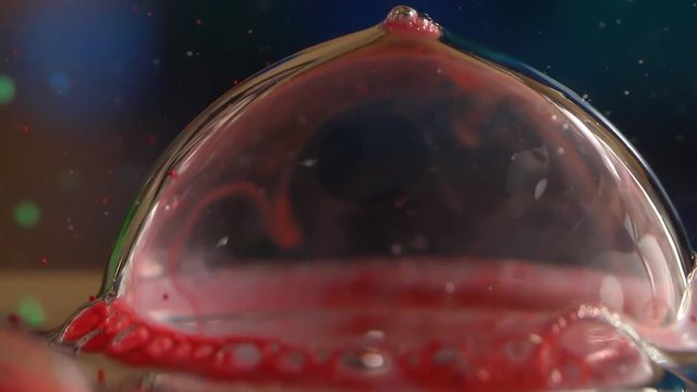 Red bubble on water pops, slow motion