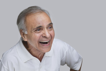 Obraz premium Elderly man laughing over colored background 