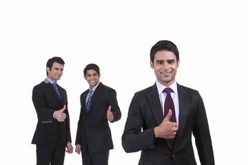Portrait of businessmen giving thumbs up